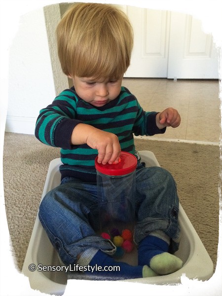 15 month toddler activity: Putting pom pom into a bottle